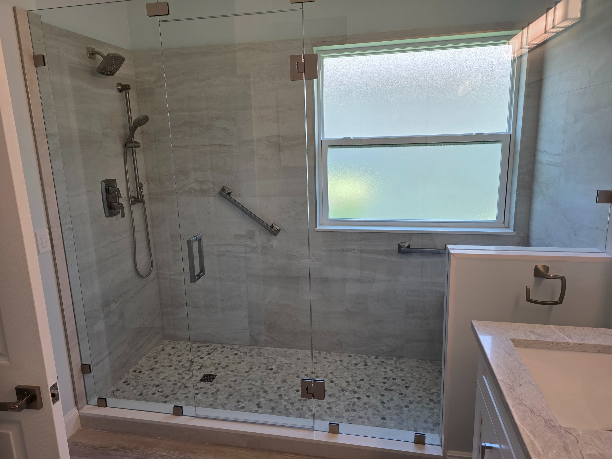 Ann's new walk-in shower Boynton Beach — frameless glass penny tile