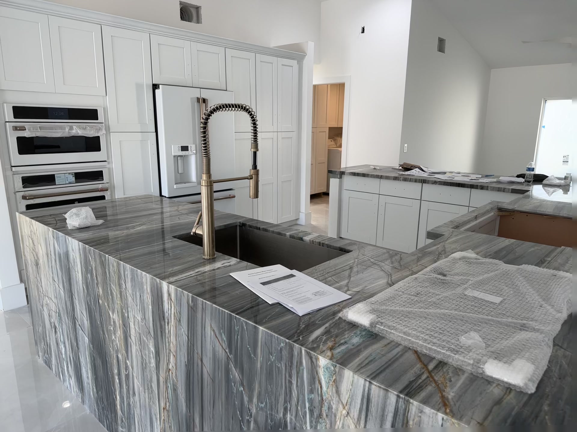 Waterfront living area after remodel — polished porcelain tile floors, open glass doors to dock