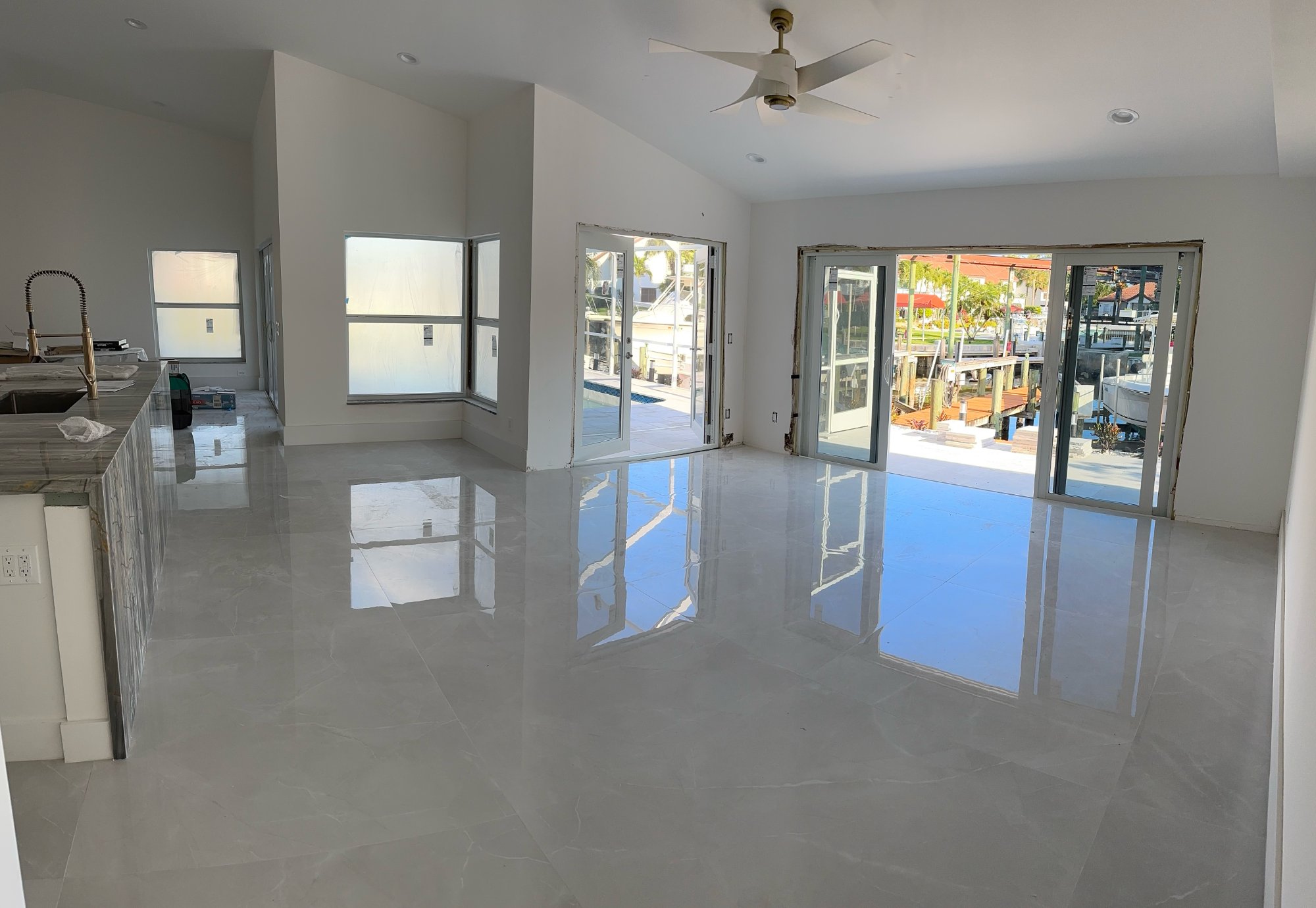 Kitchen island close-up — blue-grey marble waterfall countertop, brushed bronze faucet, undermount sink