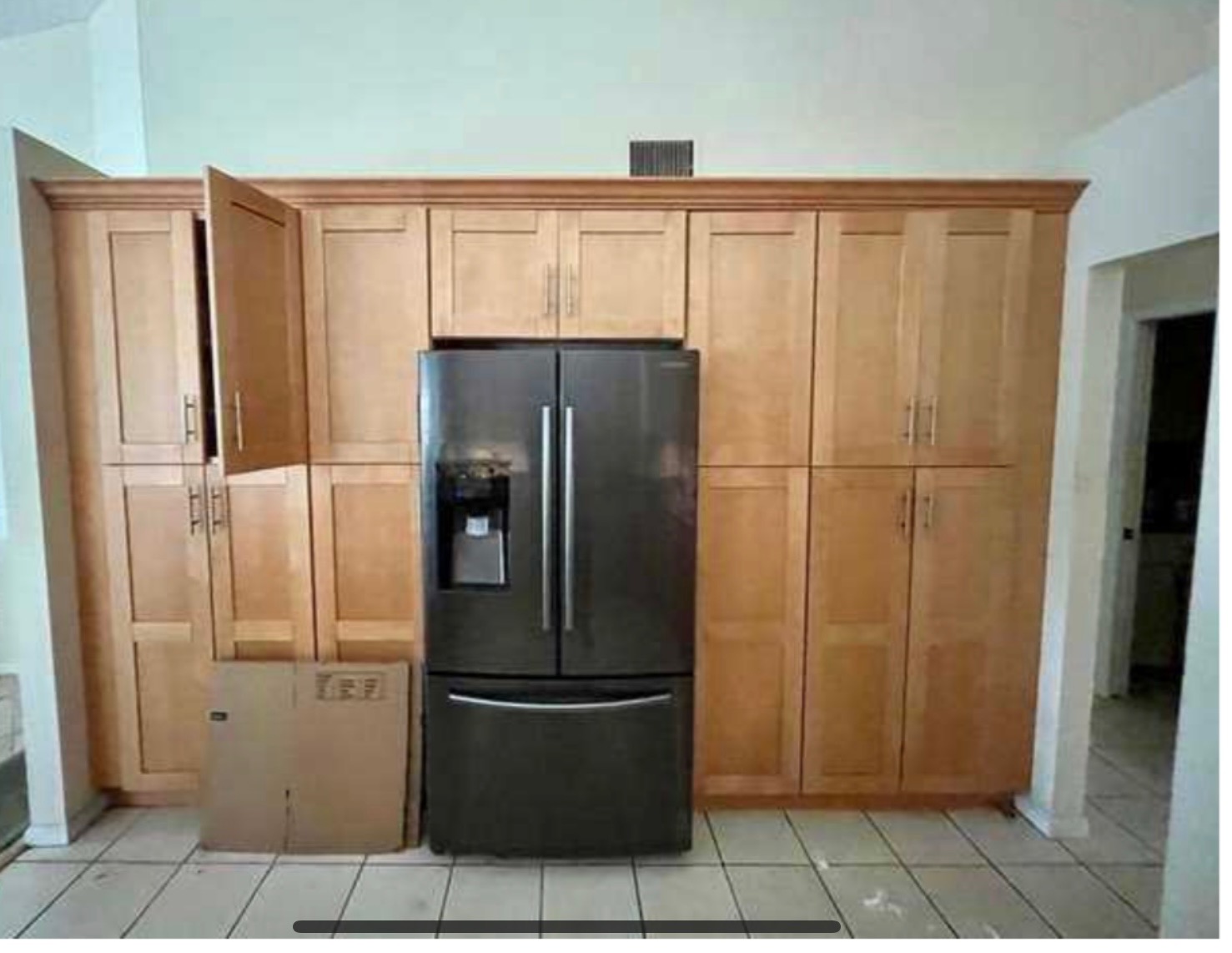 Kitchen before — original cream tile floors, black stainless appliances
