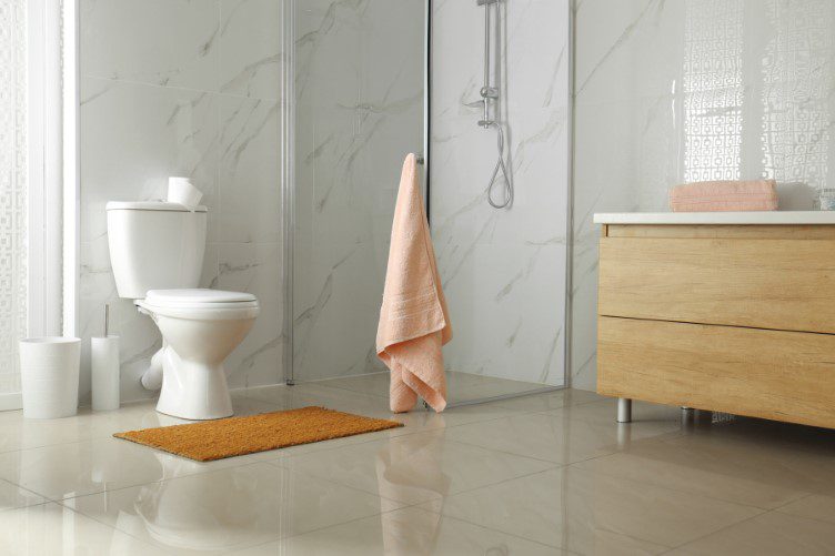 Toilet bowl near shower stall in modern bathroom interior